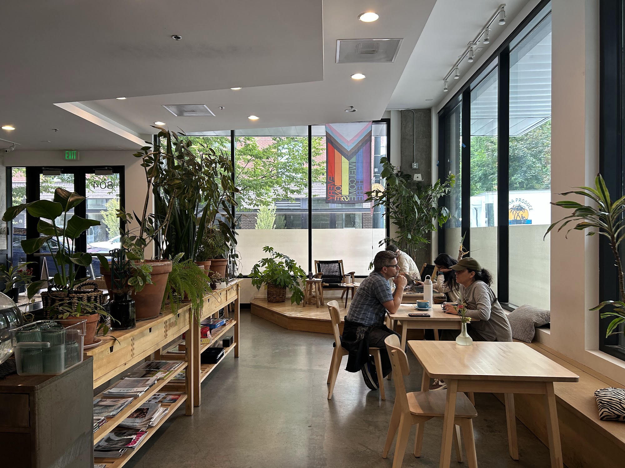 Cadejo Coffee interior with plants, tables, windows, and guests